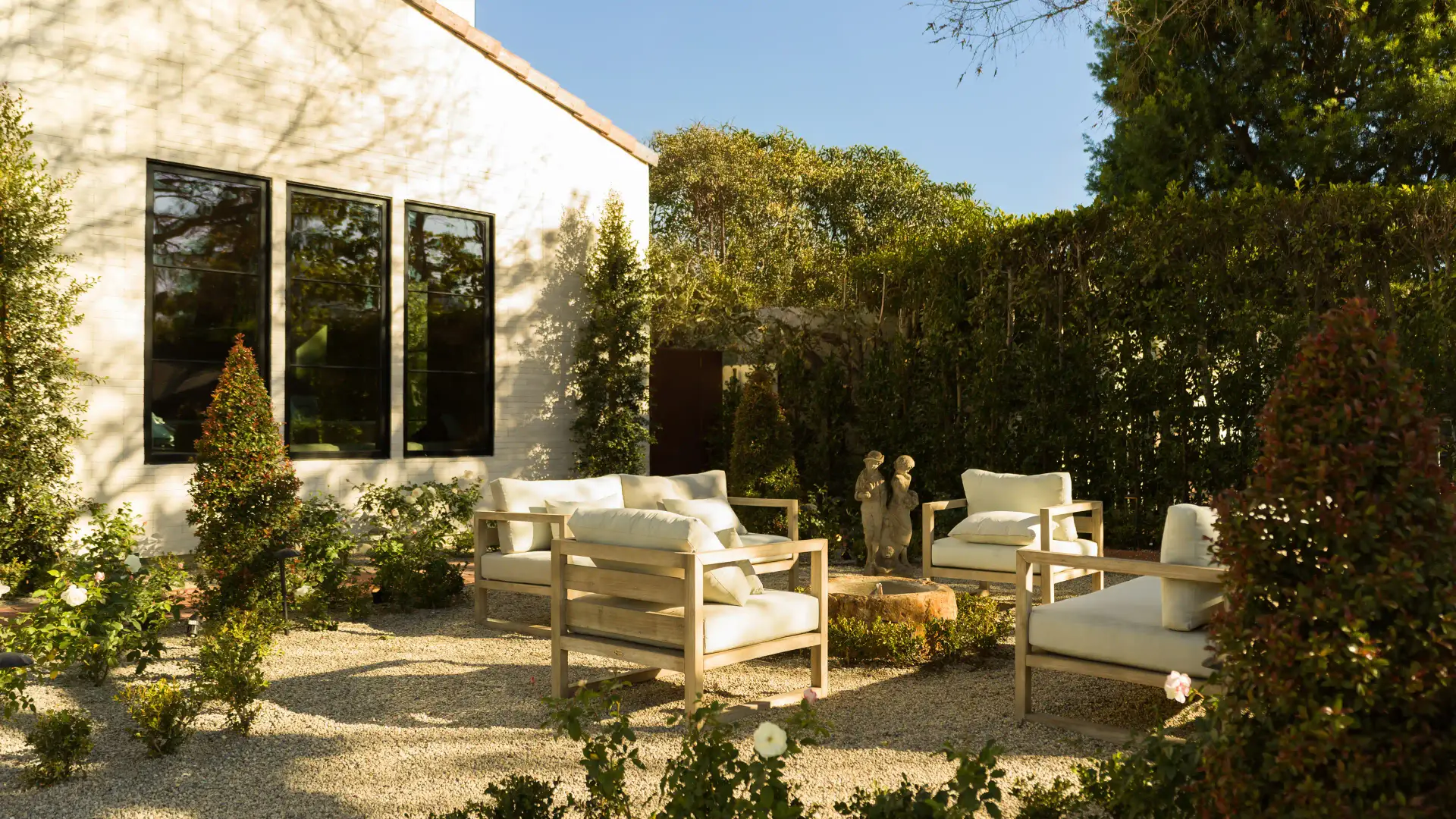 Luxury garden pool lined with potted shrubs and cypress trees